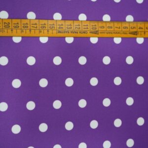 Tela flamenca morada con lunares blancos medianos, ideal para trajes de flamenca.