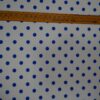 Tela flamenca blanca con lunares azul real medianos, ideal para trajes de flamenca.